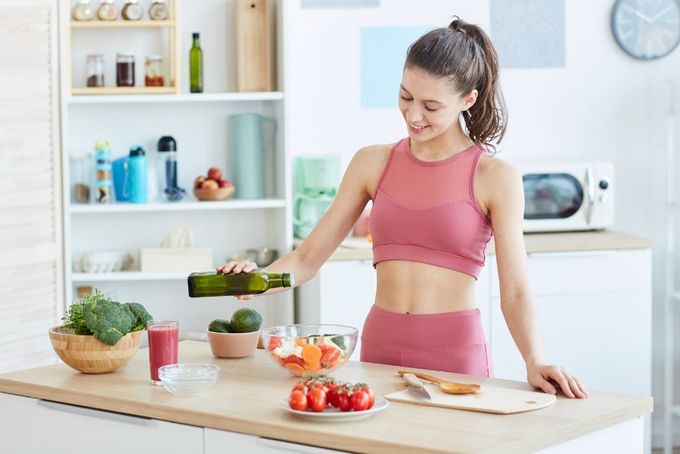 a woman standing in a kitchen preparing a meal