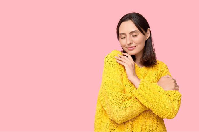 a woman in a yellow sweater posing for a picture