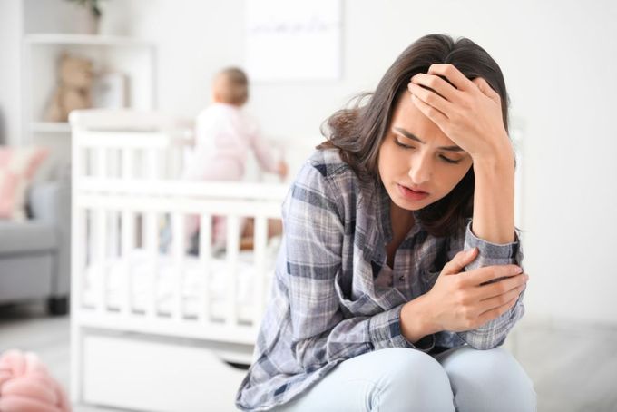 a woman sitting on the floor looking at her cell phone