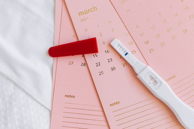 a toothbrush sitting on top of a pink calendar