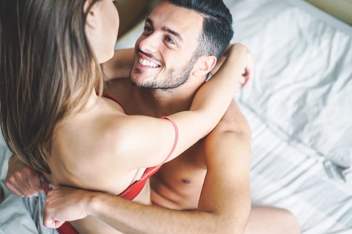 a man and a woman laying on top of a bed