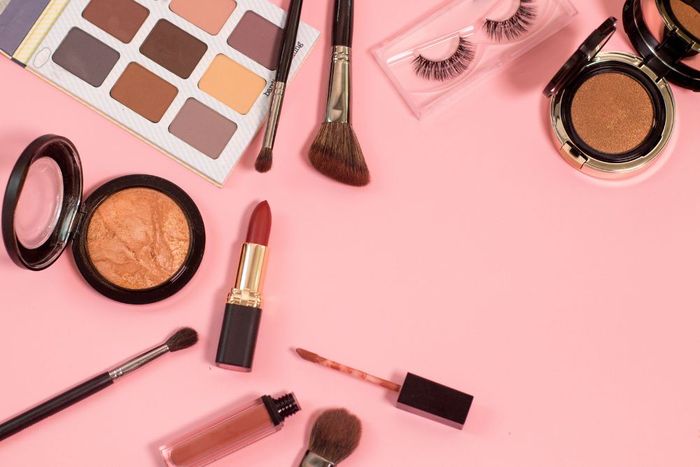 a pink background with cosmetics and eyeliners