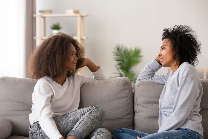 a couple of women sitting on top of a couch