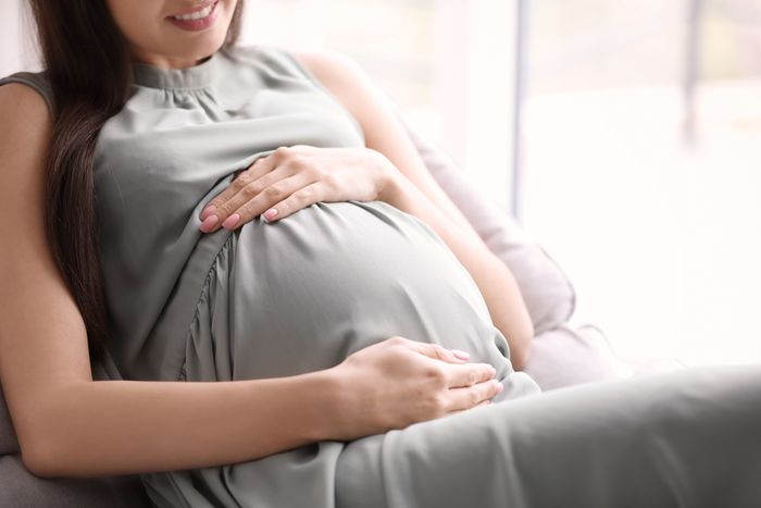 A pregnant woman holding her stomach.