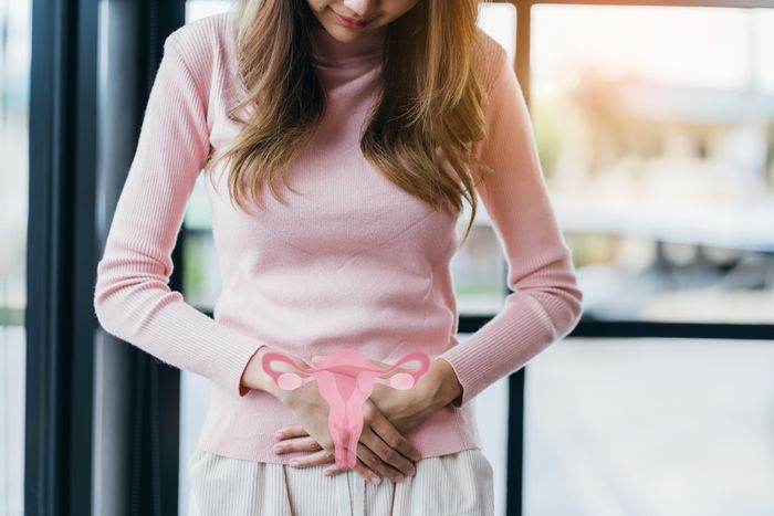 A woman is holding her stomach due to the pain