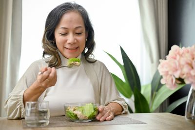Woman eating a salad and smiling