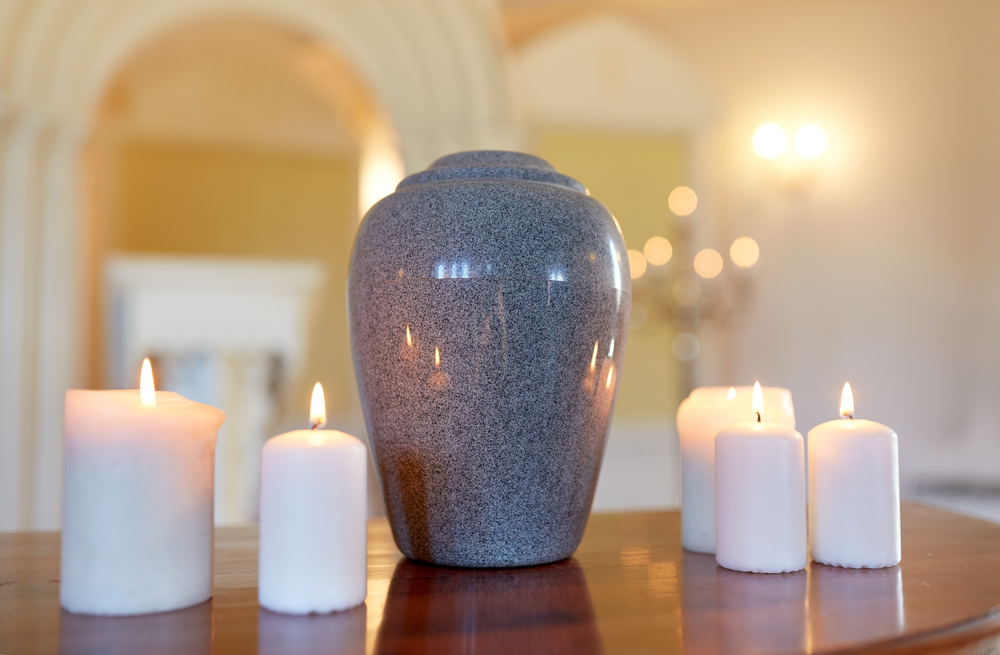 Ceramic urn next to candles on table