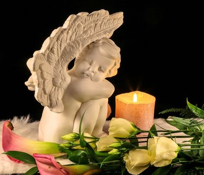 Cherub ornament with a candle and flowers