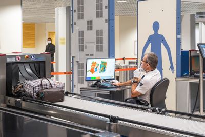 Airport security guard scanning bags through the x-ray scanner