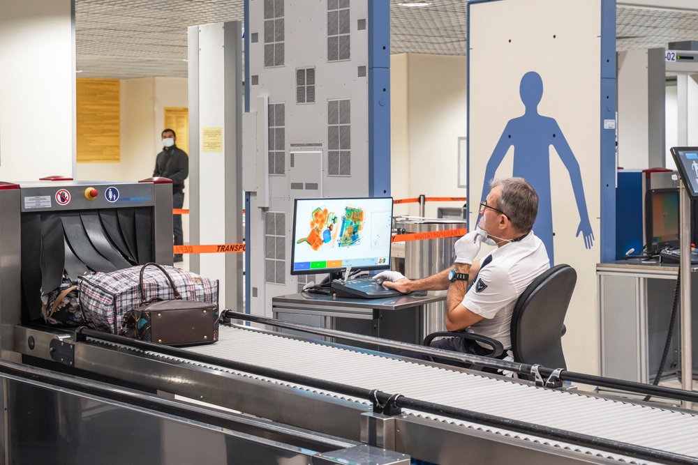 Airport security guard scanning bags through the x-ray scanner