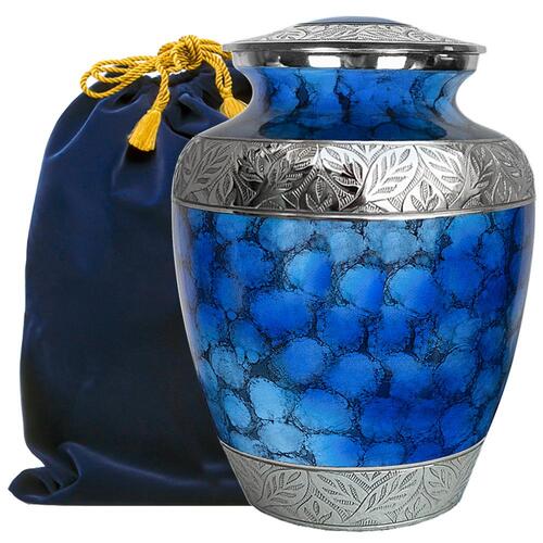 Blue cremation urn with metal leafy detailing next to a dark blue velvet bag