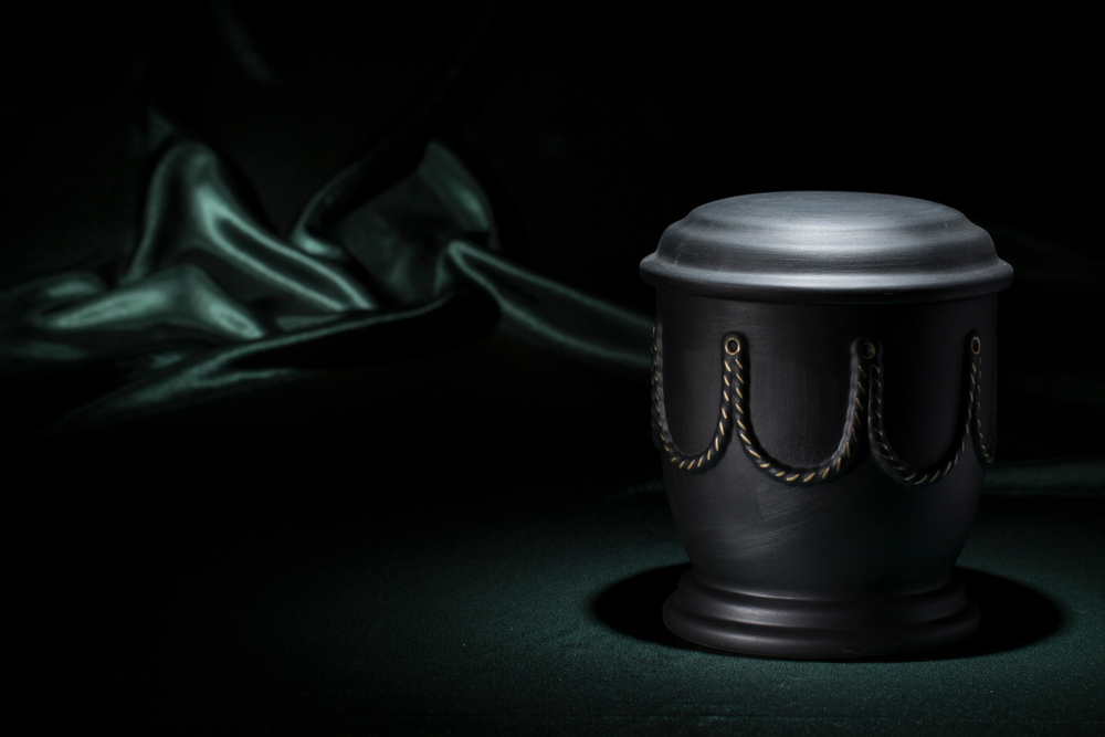 A black urn with decorations on a velvet background