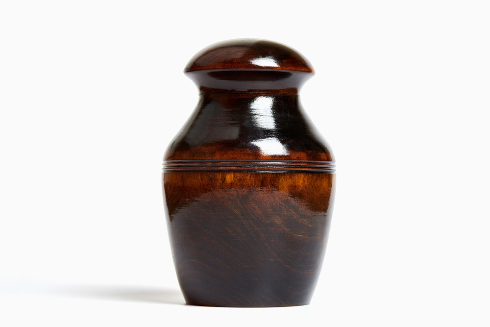 Wooden urn for ashes on a white background
