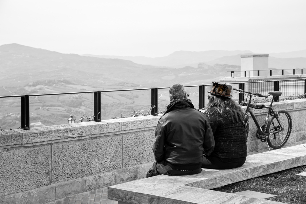 A man and a woman sitting and talking whilst overlooking a beautiful view of the land