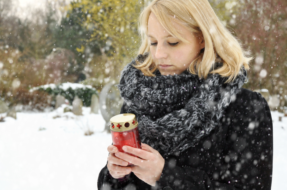 Woman in snow holding keepsake urn