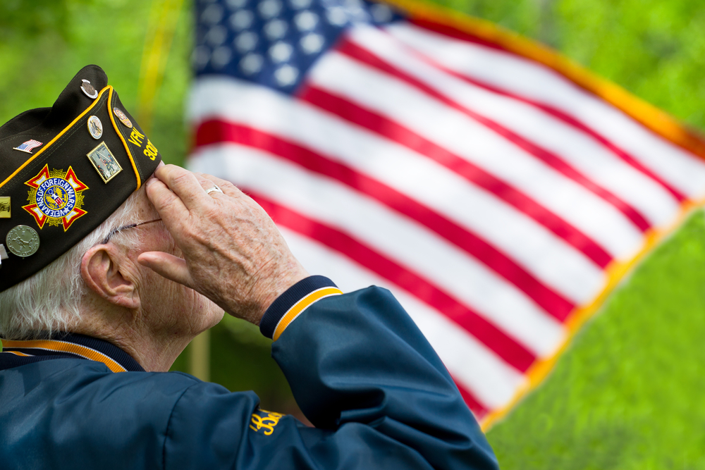 Elderly US veteran saluting the American flag
