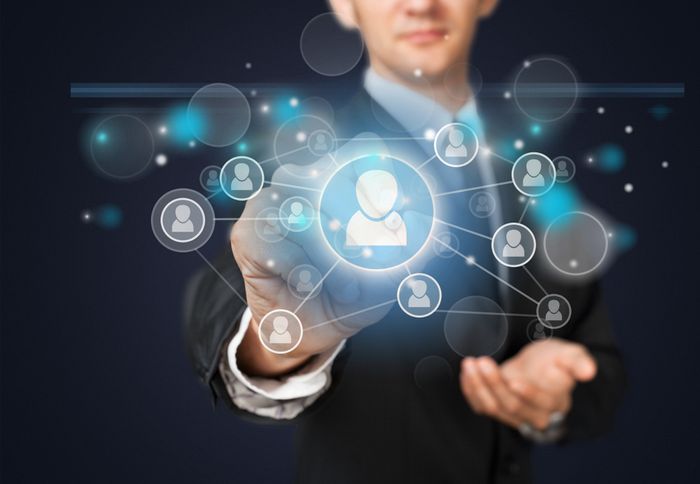 A professional man in a suit pointing to a network of employee icons