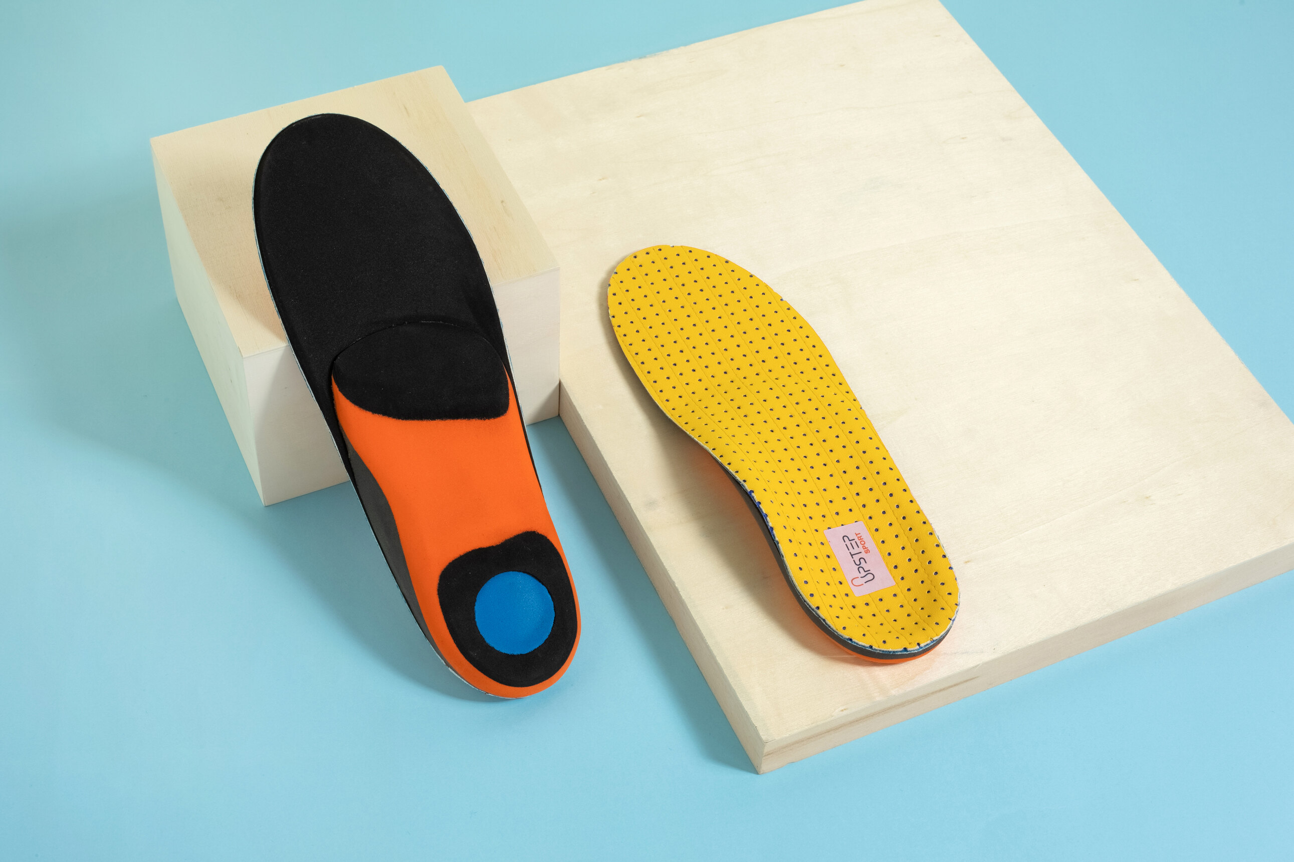 Pair of insoles displayed on blocks, showing back and front of the insoles