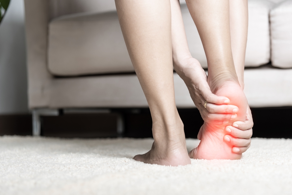 Person holding their heel in pain