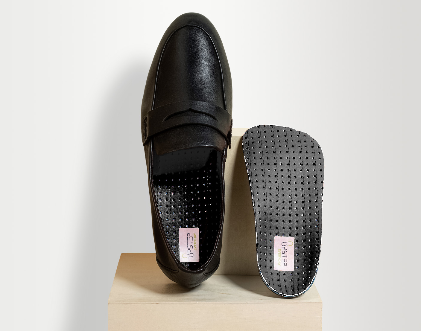 Black insole next to a black formal shoe