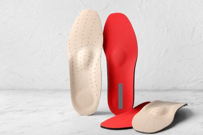 Two different pairs of insoles stacked up next to each other.