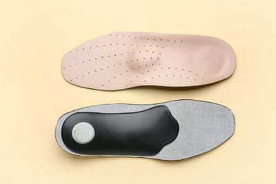 Two different kinds of insoles placed next to one another, face opposite directions.