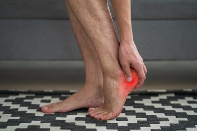 Man with plantar fasciitis massaging painful heel