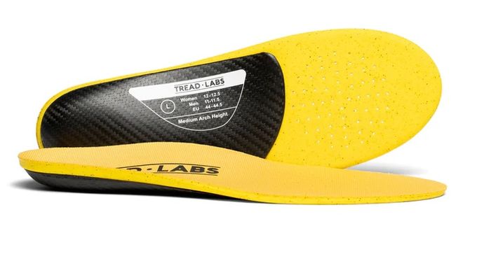 Yellow and black insoles from Tread Labs seen from the side and beneath