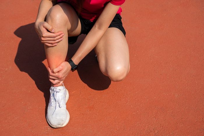 An athlete holding a painful spot on the lower shin that won't go away