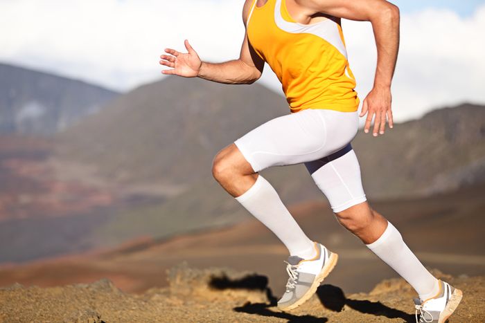 A runner mid-stride, wearing compression socks for shin splint prevention