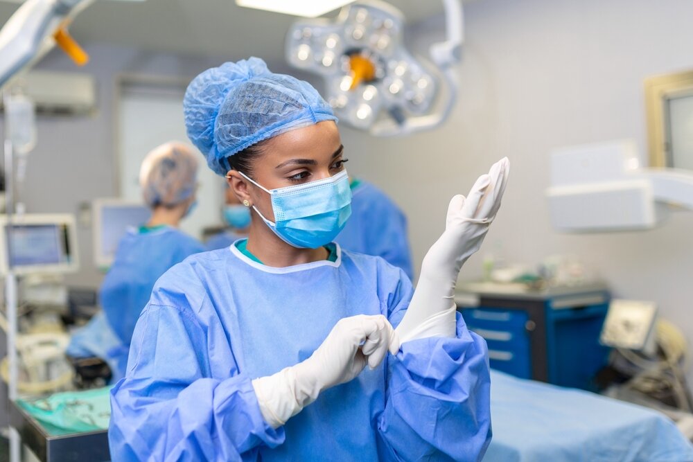 A surgeon applying her gloves prior to surgery.