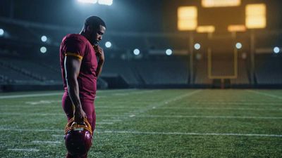 a man in a red uniform standing on a football field