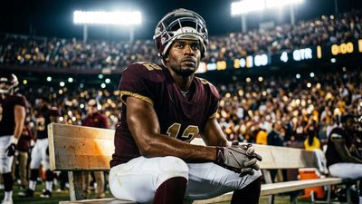 a football player sitting on a bench in a stadium