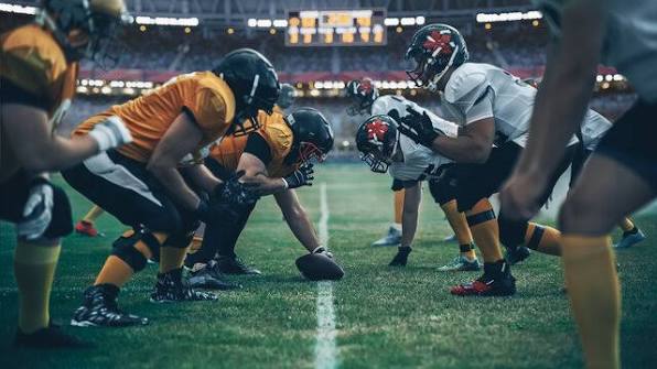 a group of football players standing on top of a field
