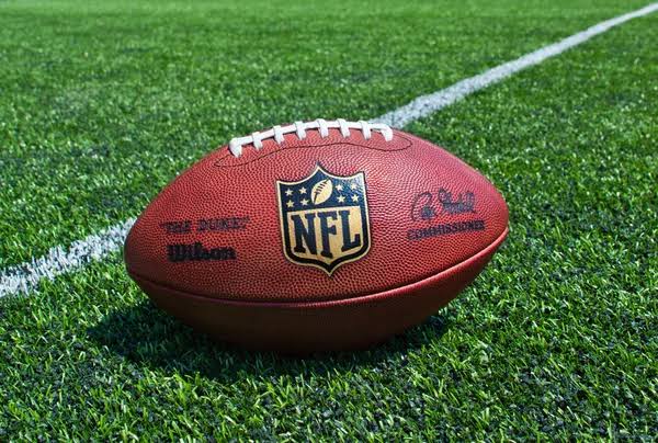 a football sitting on top of a lush green field